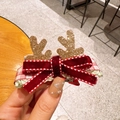 Christmas hair clip with golden glitter antlers and burgundy velvet bow on a hand - Bow Antler Hairpin