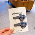 Pair of heart-shaped grey and blue plaid hair clips with white stitched edges - Checkered Heart