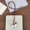 Detail of handcrafted embroidered alpaca charm with colorful saddle on a wooden tray - Alpaca