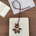 Detail of a brown hand-knitted bear pendant with cream scarf and metallic accents - Strong Brown Rabbit