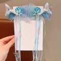 Detail of mermaid bow hair clips with long tassels, sea shells, and colorful ribbons - Blue Purple Starfish Style