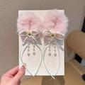 Roze pluche haarstrikken met parelkwastjes en lichtgroene linten in de hand getoond - Roze Strik Bloem Kralenketting