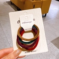 Set of 4 velvet bow scrunchies in brown, purple, green, and red on display card - Colored Hair Rings 1