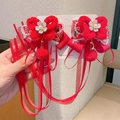 Paar rote Plüsch-Haarspangen im Neujahrs-Design mit weißen Blumen und langen Bändern - Schmetterling Pompon Anhänger