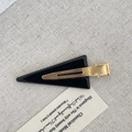 Minimalist black triangle acetate hair clip with gold metal grip on linen fabric - Black