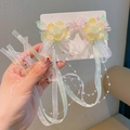 Paar florale Haarspangen mit Schmetterlingsstickerei und langen Quasten in der Hand - Gelbe Fünfblättrige Blume