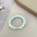 Mint green pleated fabric scrunchie with a square resin buckle on a minimalist background - Green Hair Tie