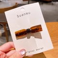 Barrette nœud en acétate écaille de tortue ornée de strass colorés sur présentoir - Nœud Papillon Café