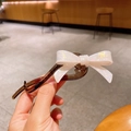 Eleganter Haarclip mit weißer schillernder Schleife und dunkelbraunem Acryl-Twist-Design - Weiß