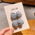 Detail showing two grey handmade bow hair clips with silver thread on a 10cm card - Gray