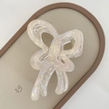 Detailed macro view of pearlescent jelly butterfly hair claw clip with gold metal spring - Beige