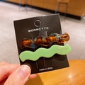 Wavy acetate hair clips set in tortoiseshell and light green with golden lettering - Verdant