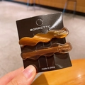 Brown marble and translucent wavy hair clip set on a black branded display card - Brown