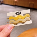 Matte yellow and creamy white wavy acetate hair clips with gold label detail - Yellow Series