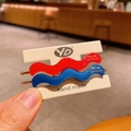 Set of wavy red and blue resin hair clips on a white display card with gold branding - Red & Blue