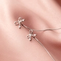 S925 Sterling Silber Schleifen Ohrhänger mit Zirkonia auf rosa Satin Hintergrund - Silber