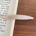 Pinza para el pelo de acetato perlado con base de metal dorado sobre página de libro viejo - 3-Blanco Mágico