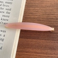 Pinza para el pelo de acetato rosa con letras doradas sobre un libro antiguo - Rosa