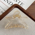 Transparent star-shaped hair claw clip with gold metal spring on textured fabric - Clear White