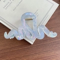 Pinza para el pelo ondulada azul claro iridiscente con acabado láser sobre libro - Azul