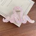 Pince à cheveux en acrylique rose nacré avec design ondulé sur un livre ancien - Rose