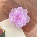 Eleganter violetter Organza Blumen-Haarclip mit Perlenmitte auf einem Holztablett - Lila