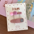 Pink and purple fabric hair clips for girls set on a decorative white card display - Pink Pompom Style