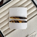 Zwei elegante Acetat-Haarspangen mit Schildpatt-Muster auf Marken-Verpackung - Dunkles Leopardenmuster