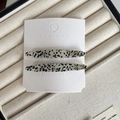 Elegant pair of black and white spotted acetate barrette clips on a display card - Black and White