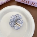 Scrunchie a fiori bianchi e blu con etichetta MIAOJI su un piatto di ceramica - Porcellana Blu e Bianca