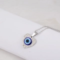 Primer plano de un colgante de corazón plateado con ojo turco azul y cristales finos - Colgante de Corazón Mal de Ojo Plata Solo (Sin Cadena)