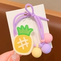 Détail d'un élastique à cheveux violet avec breloque ananas et perles colorées - Style Ananas