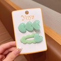 Primo piano di due fermagli per capelli a cuore verde chiaro con resina glitterata - Verde