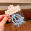 Set aus zwei hellblauen Spiral-Haargummis mit glitzernden Sternen in Originalverpackung - Haargummi / Blaues Haargummi