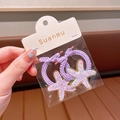 Zwei lila Stern-Haargummis mit Glitzer-Anhängern und geflochtenen Elastikbändern - Haargummi / Lila Scrunchie