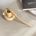 Primer plano de un pasador de pelo minimalista de metal dorado de 16cm sobre cuero gris - Dorado