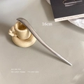 Detalle de un pasador de pelo minimalista de metal plateado de 16cm sobre superficie de cuero - Plateado