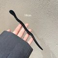 Detailopname van een 18 cm zwarte golfvormige haarstok met een gepolijste glanzende look - Zwart