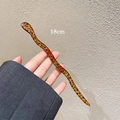 Detail van een 18 cm golvende haarpin van acetaat met een klassiek schildpadpatroon - Theebruin