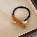 Premium elastic hair tie featuring amber resin and golden hammered metal accents - Caramel color