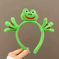 Détail du serre-tête grenouille en peluche verte avec de grands yeux et de jolies pattes - Serre-tête Grenouille Câlin