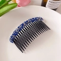 Eleganter schwarzer Haarkamm mit blauen und silbernen Strasssteinen auf weißem Teller - Blau