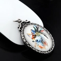 Close-up of vintage silver oval pendant featuring a colorful fox with feather headdress - Nine-Tailed Fox 2 Thangka Pendant with 60cm Emperor Chain