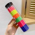 Dettaglio degli elastici per capelli colorati senza cuciture nel cilindro di conservazione - Lampada fluorescente