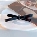 Classic French black acetate bow hair clip with a glossy finish and golden metal spring clip - Black