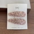 Set mit zwei glänzenden rosa Glitzer-Haarclips für Kinder auf weißer Karte - Champagnerrosa