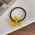 Minimalistisches elastisches Haargummi mit gelbem Acryl-Blumenanhänger auf weißem Netz - Blumengelb