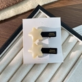Fermaglio per capelli a stella in acetato panna e nero su scheda di esposizione - Stile Stella Bianco