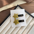 Set di due fermagli per capelli a stella giallo senape con base nera su carta - Stile Stella Giallo Zenzero
