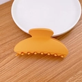 Minimalist matte yellow hair claw clip with geometric design on a wooden table - Yellow
